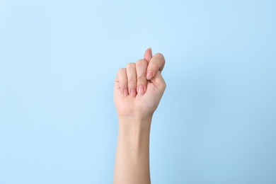Photo of Woman showing T letter on color background, closeup. Sign language