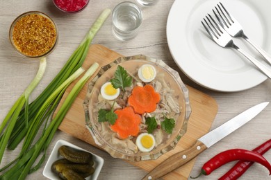 Photo of Delicious aspic with meat and vegetables served on light wooden table, flat lay