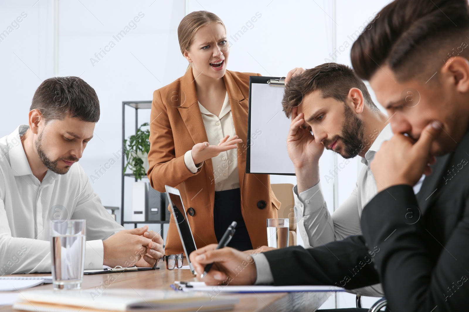 Photo of Boss screaming at employees in office. Toxic work environment
