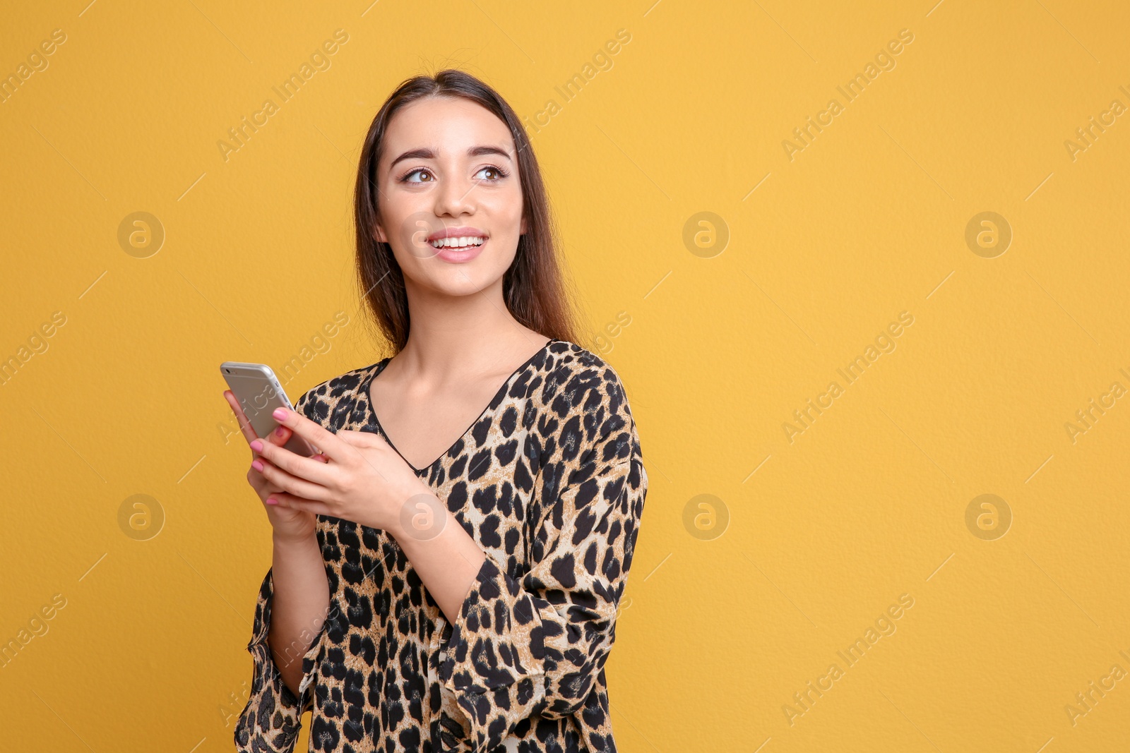 Photo of Attractive young woman using mobile phone on color background