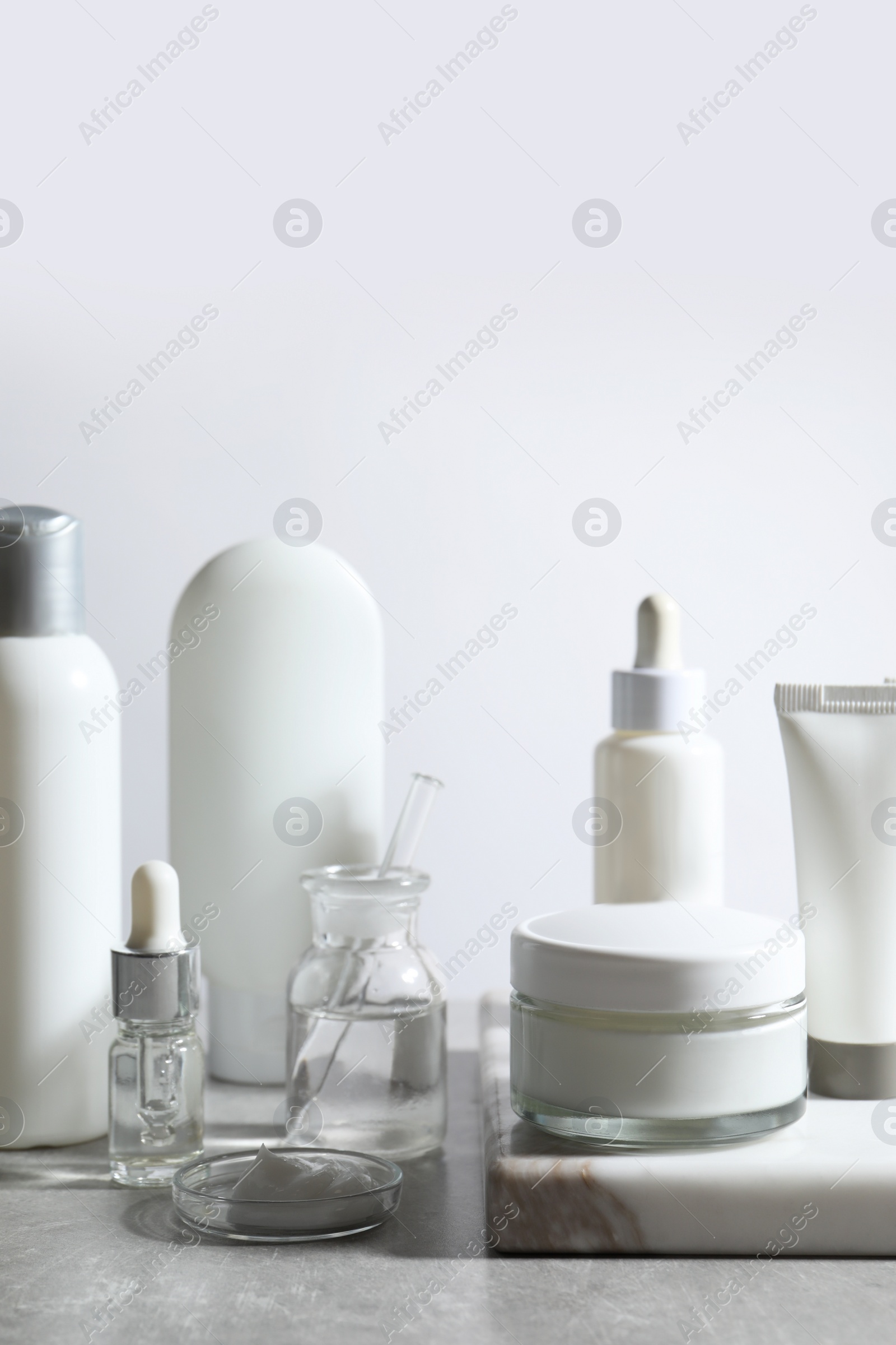 Photo of Organic cosmetic products and laboratory glassware on white table