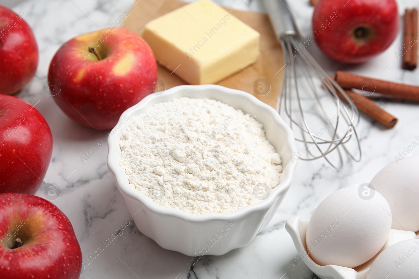 Photo of Traditional English apple pie ingredients on white marble table, closeup