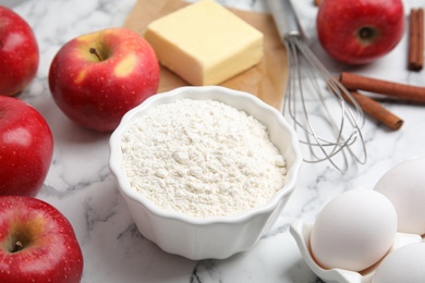 Traditional English apple pie ingredients on white marble table, closeup