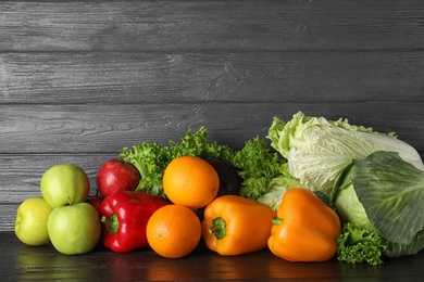 Photo of Pile of fresh fruits and vegetables on black table, space for text