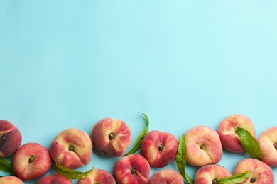 Photo of Fresh donut peaches on light blue background, flat lay. Space for text