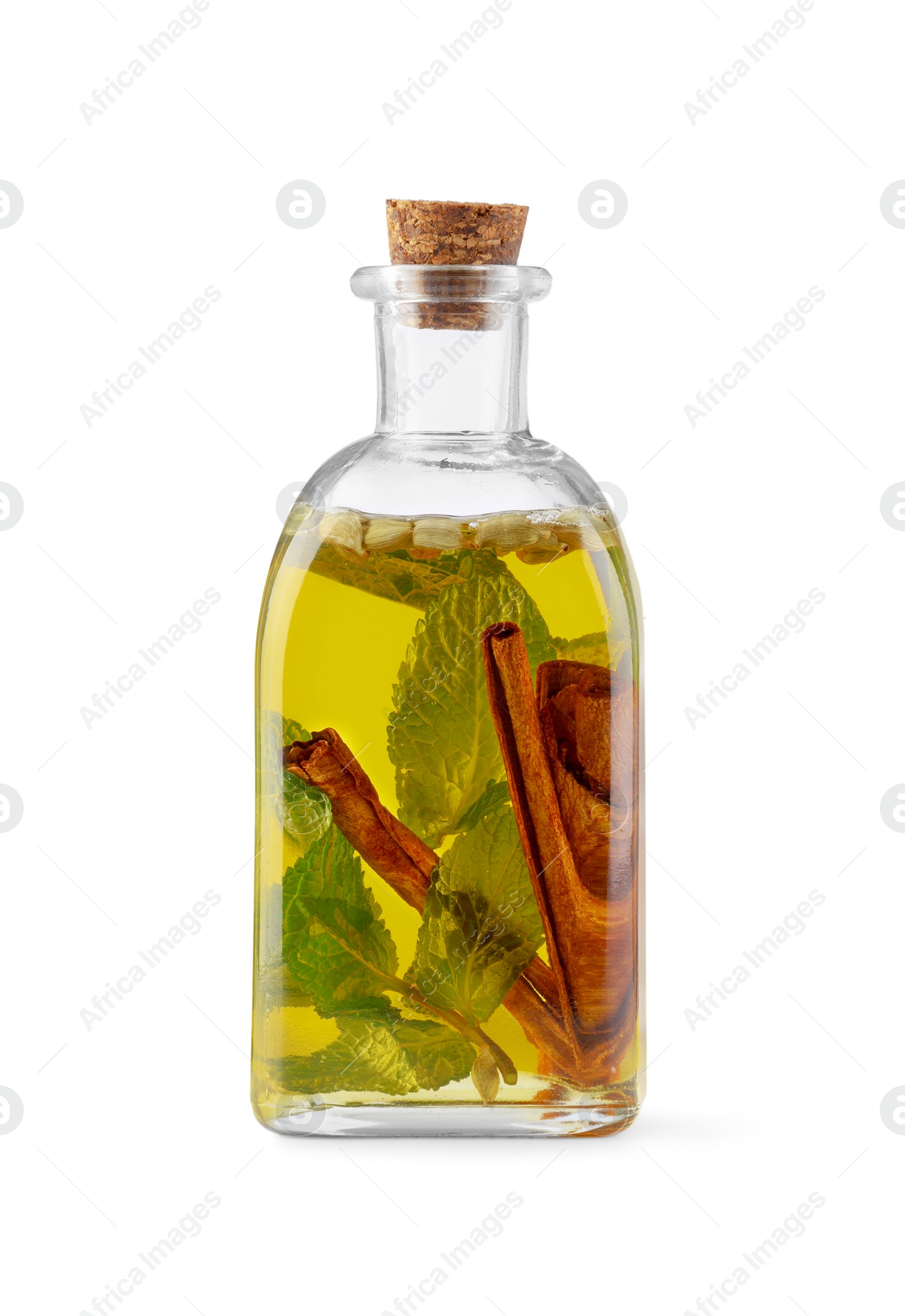 Photo of Glass bottle of cooking oil with spices and herbs isolated on white