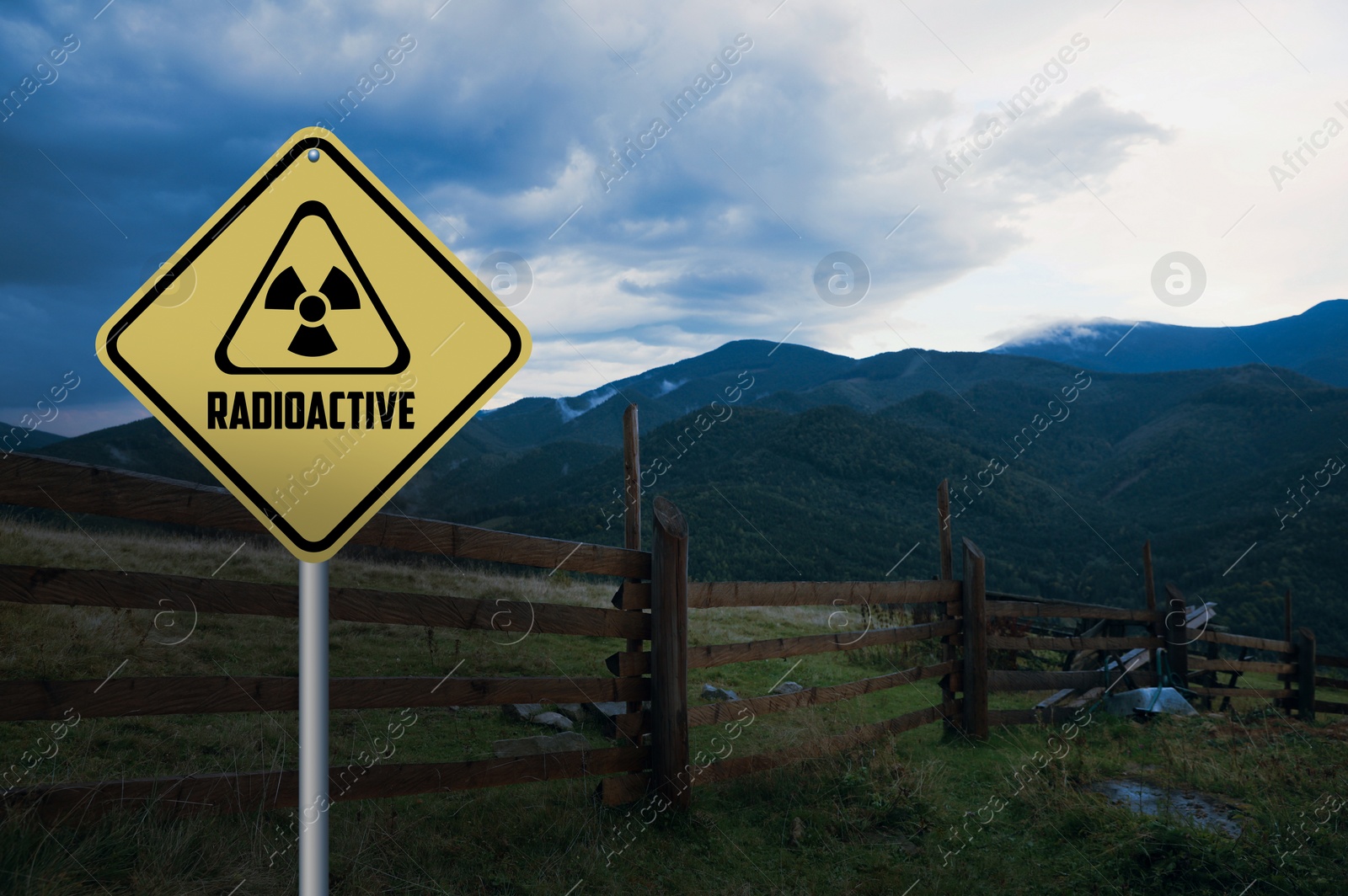 Image of Radioactive pollution. Yellow warning sign with hazard symbol in mountains