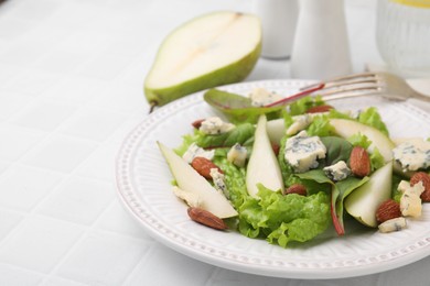 Photo of Delicious pear salad on white tiled table, closeup. Space for text