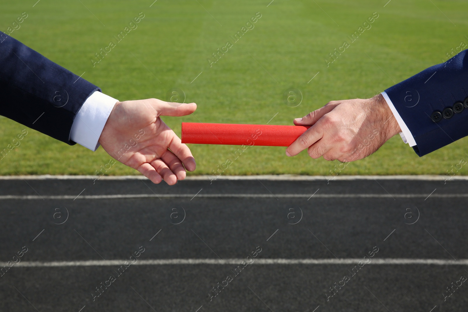 Photo of Businessman passing baton to his partner outdoors, closeup