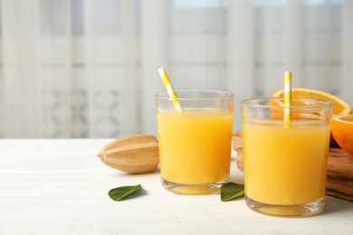 Composition with orange juice and fresh fruit on table, space for text