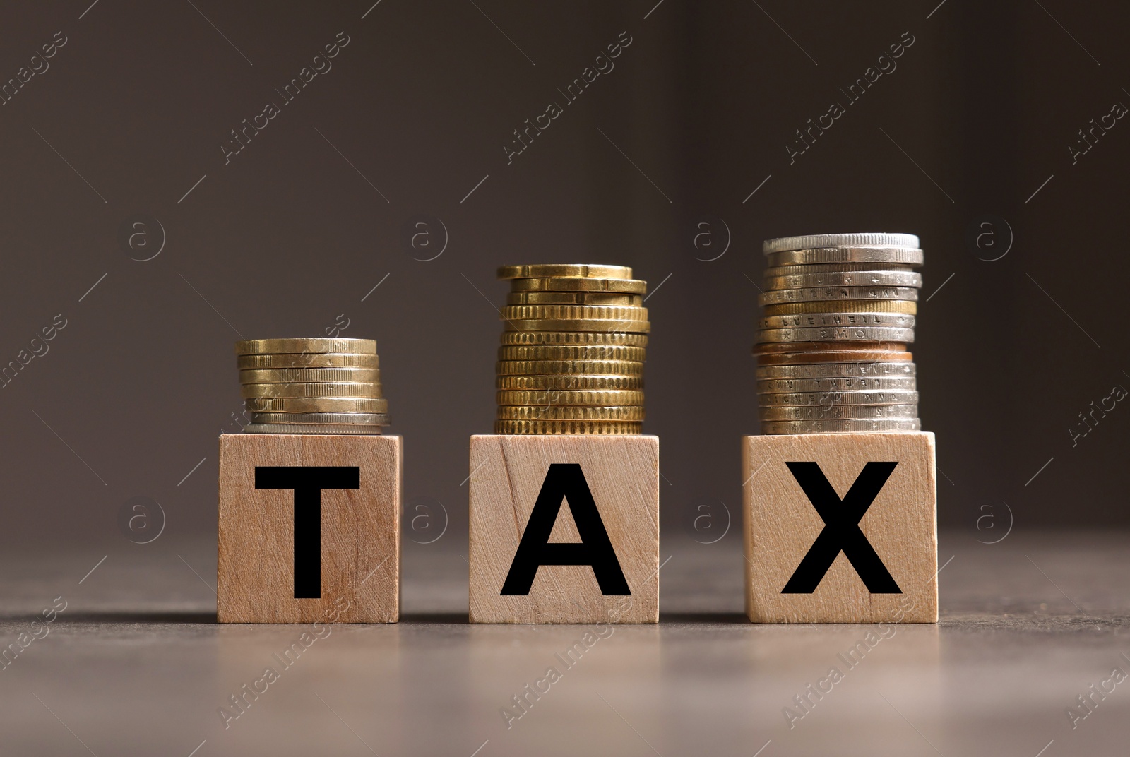Photo of Word Tax made of wooden letters and coins on grey table, space for text