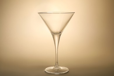 Elegant empty martini glass on beige background