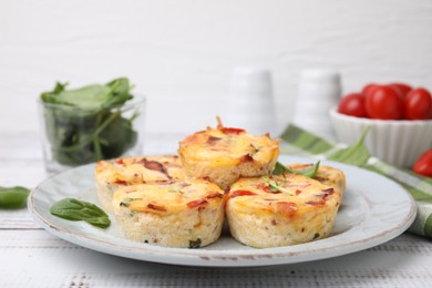 Photo of Delicious egg muffins with cheese and bacon on white wooden table, closeup. Space for text