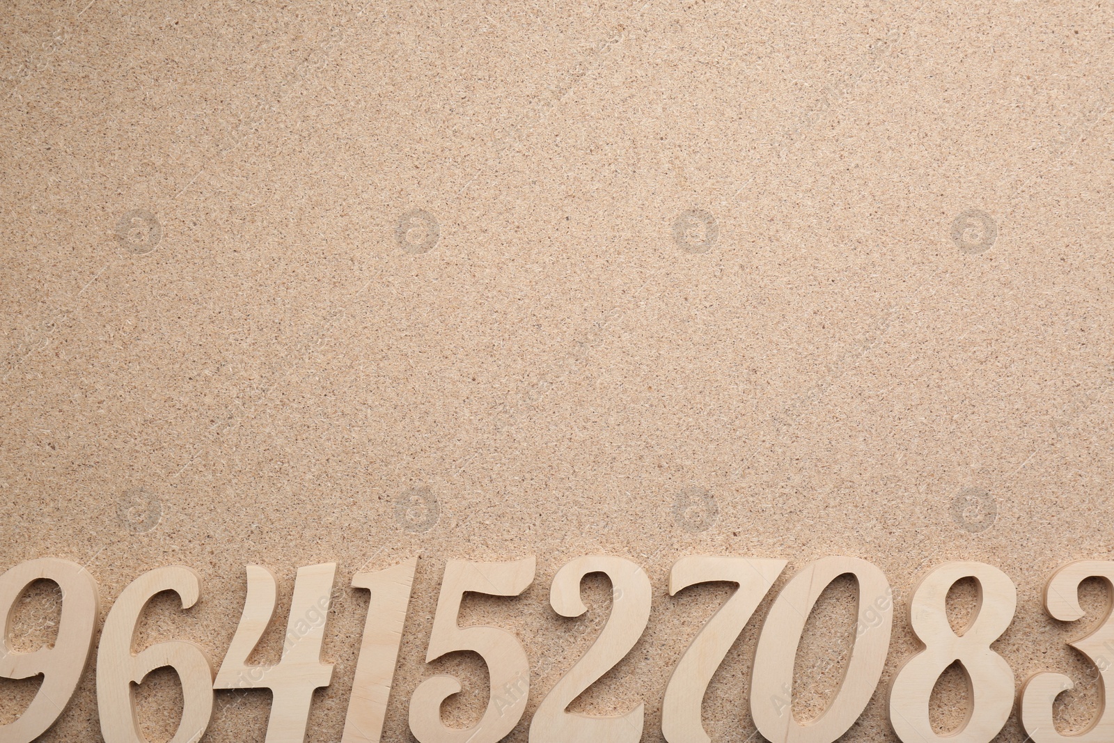 Photo of Wooden numbers on fiberboard, flat lay. Space for text