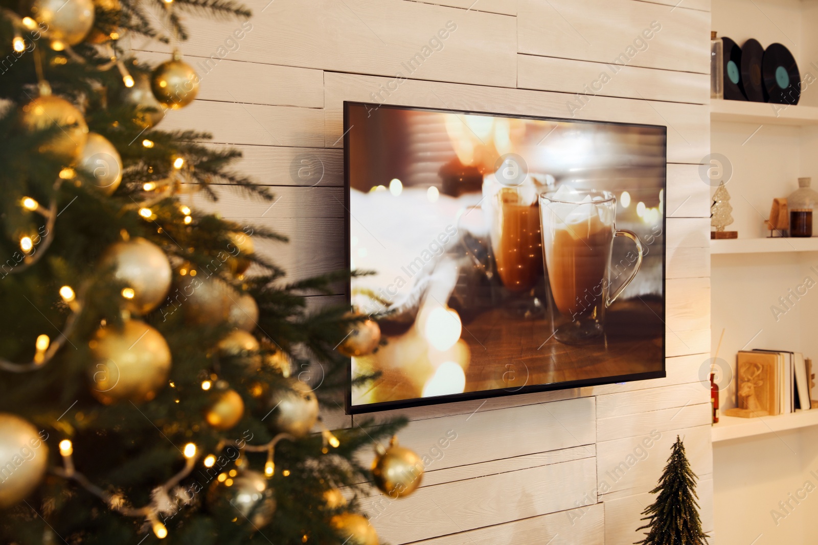 Photo of Plasma TV on white wooden wall in living room beautifully decorated for Christmas