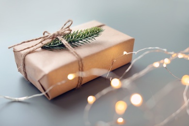 Photo of Beautiful Christmas gift box and electric garland on table