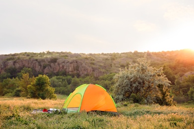 Photo of Small camping tent in wilderness on sunny day
