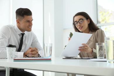 Photo of Office employees talking at table during meeting