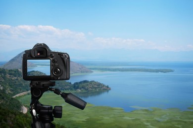 Taking photo of beautiful cove with camera mounted on tripod