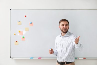 Photo of Portrait of young teacher near whiteboard in classroom