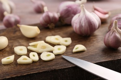 Photo of Fresh garlic and knife on table, closeup