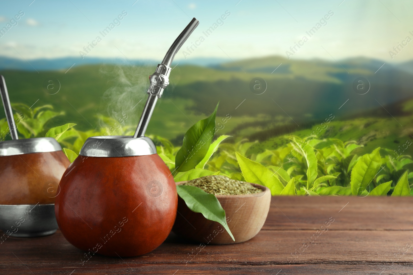 Image of Calabashes with mate tea and bombilla on wooden table. Space for text