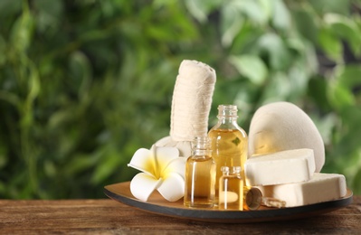 Photo of Beautiful spa composition with aroma oil and soap bars on wooden table. Space for text