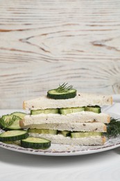 Photo of Tasty cucumber sandwiches with sesame seeds and dill on white wooden table, space for text