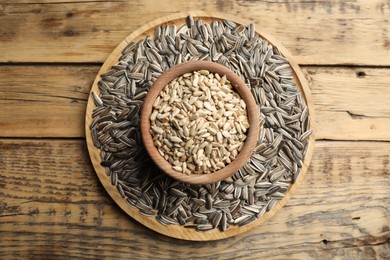 Raw sunflower seeds on wooden table, top view