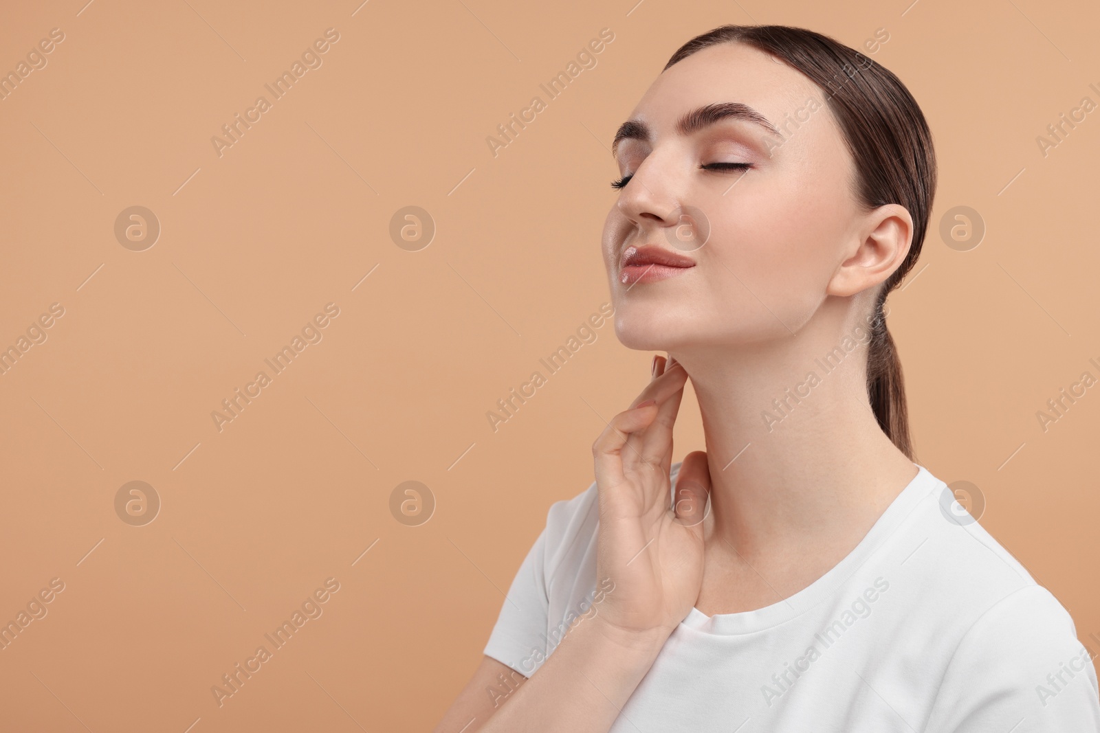 Photo of Beautiful woman touching her neck on beige background. Space for text