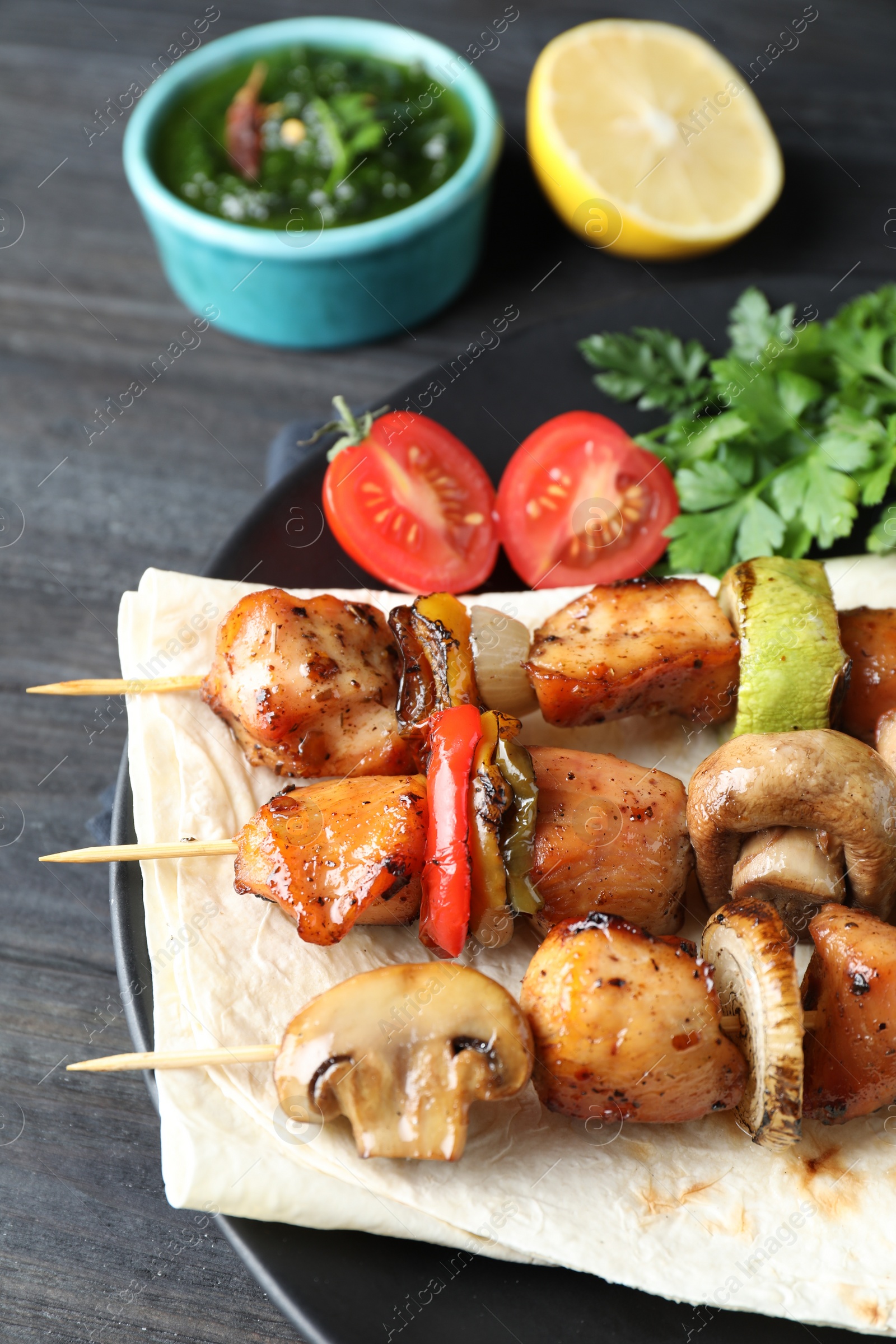 Photo of Delicious shish kebabs with vegetables served on table, closeup