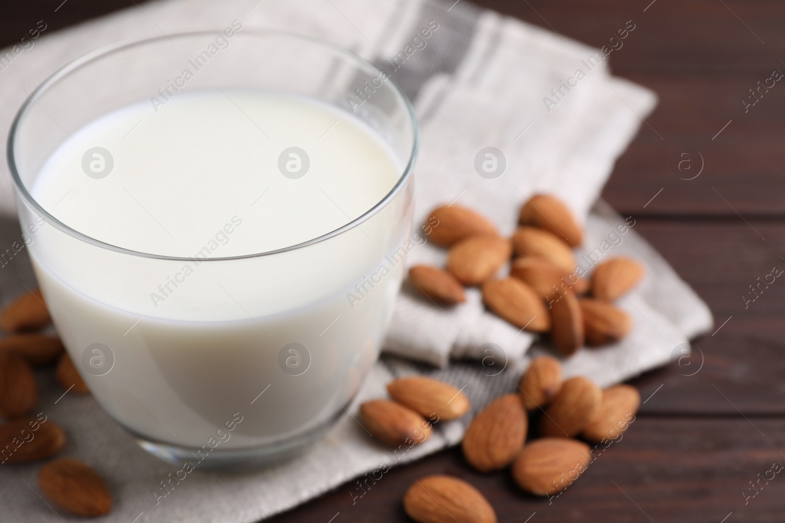 Photo of Glass of almond milk on wooden table, closeup