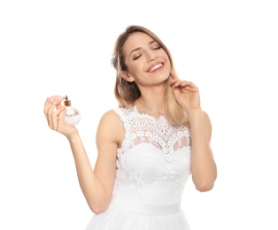 Beautiful young bride with bottle of perfume on white background