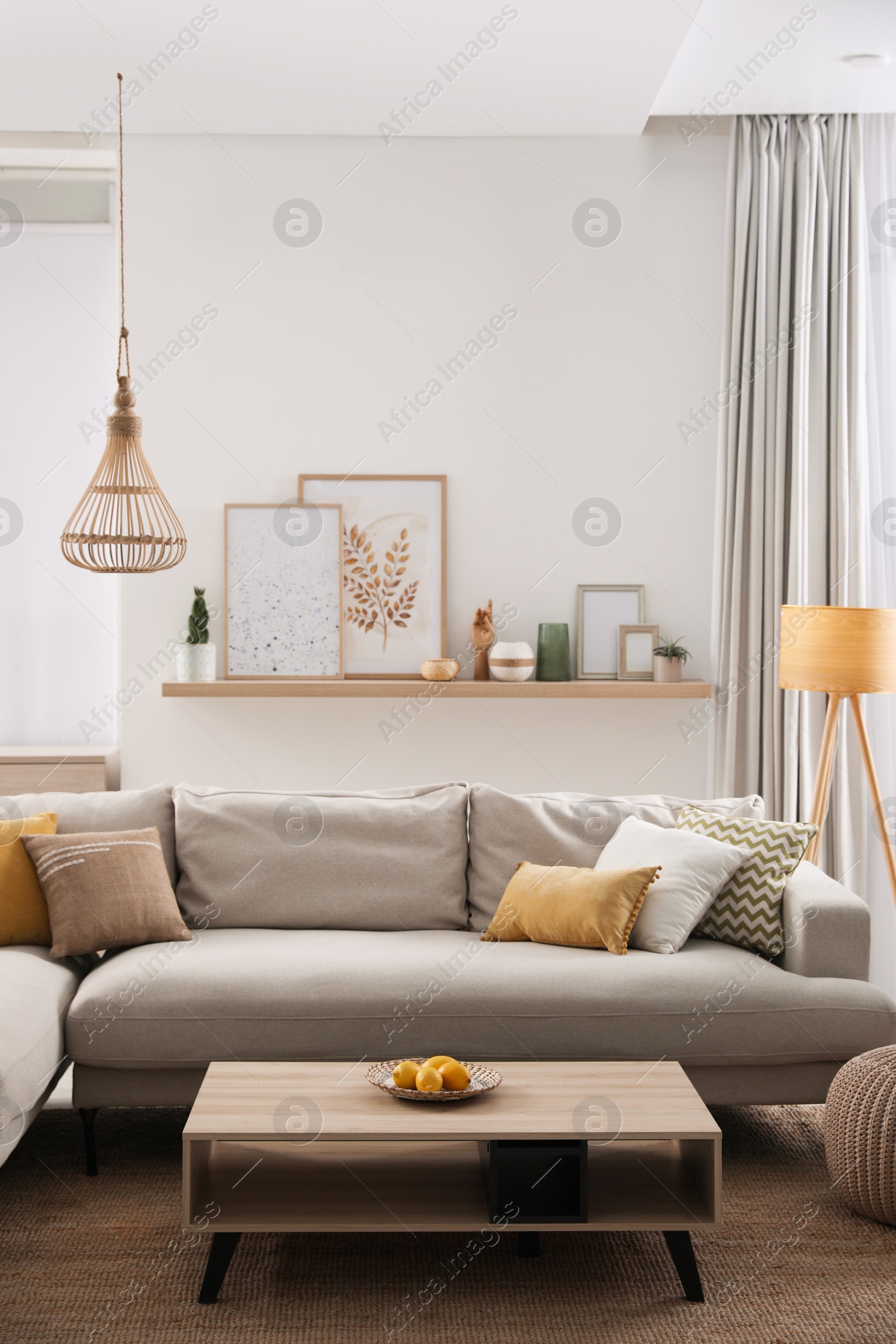 Photo of Stylish living room interior with comfortable grey sofa and coffee table