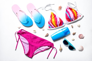 Photo of Flat lay composition with bikini and beach objects on white background