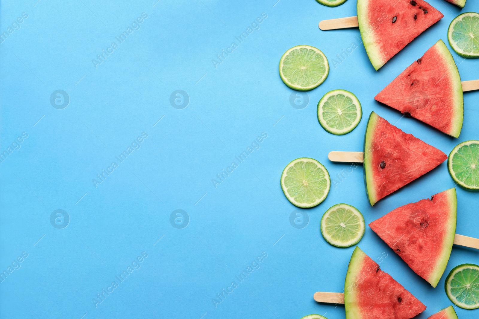 Photo of Tasty sliced watermelon and limes on light blue background, flat lay. Space for text