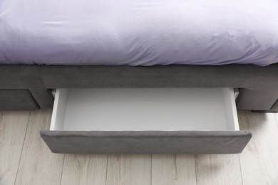 Storage drawer for bedding under modern bed in room, above view