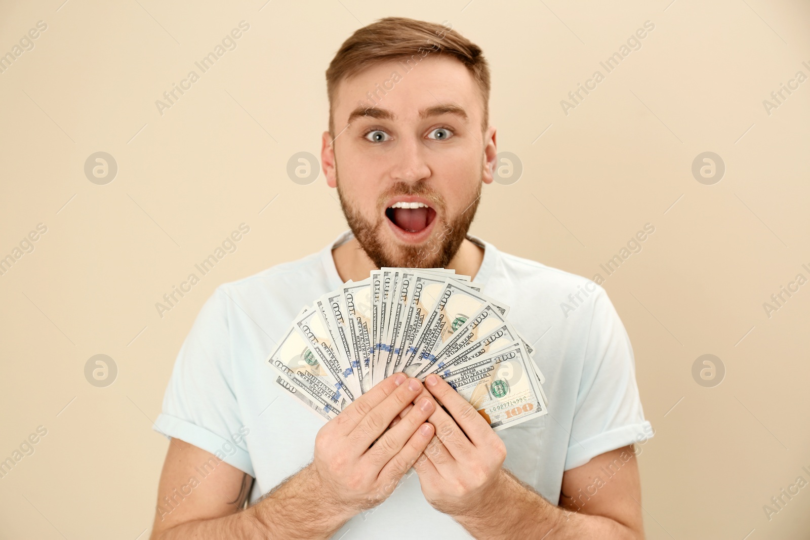 Photo of Portrait of emotional young man with money on color background