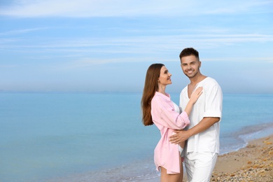 Photo of Young woman in bikini with her boyfriend on beach, space for text. Lovely couple