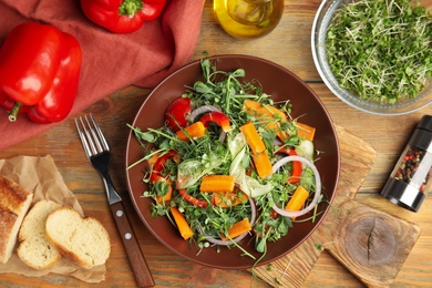 Photo of Delicious vegetable salad with microgreen served on wooden table, flat lay