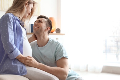 Young pregnant woman with her husband at home