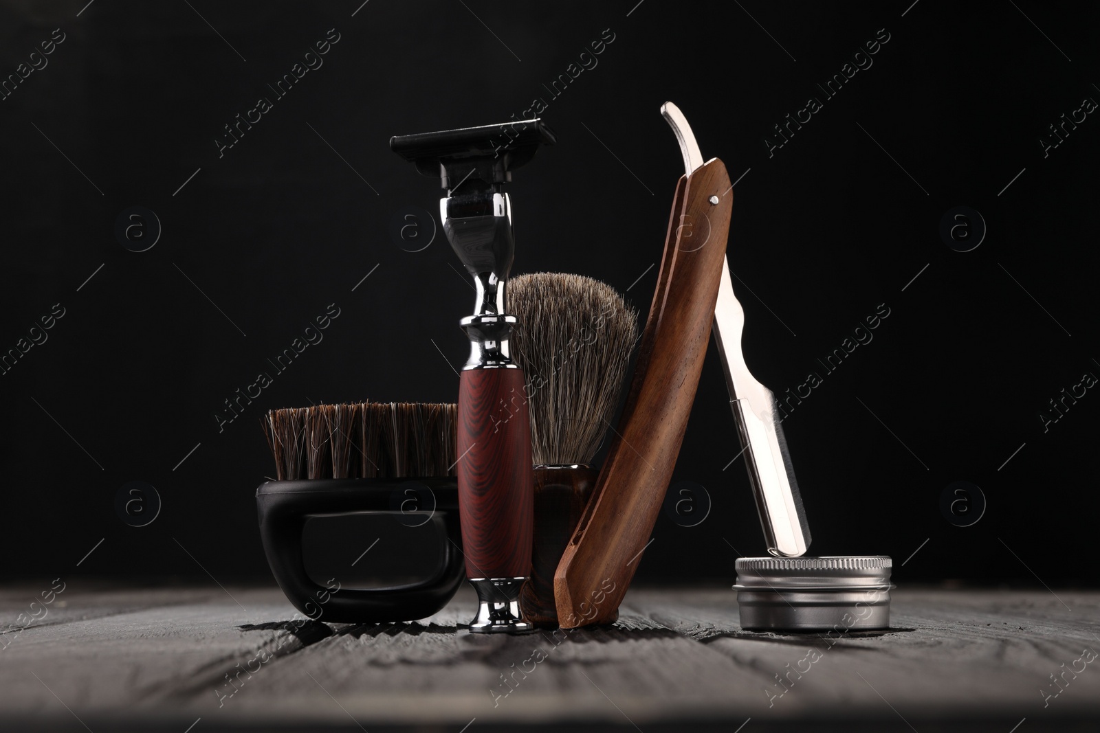 Photo of Moustache and beard styling tools on wooden table