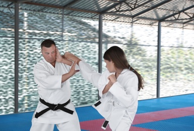 Photo of CHERNOMORKA, UKRAINE - JULY 10, 2020: Little girl with instructor practicing karate on training ground
