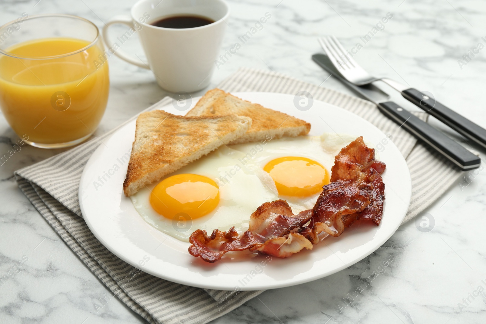 Photo of Delicious breakfast with sunny side up eggs served on white marble table, closeup