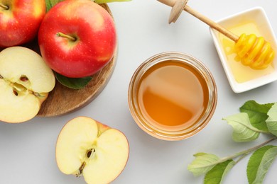 Photo of Sweet honey and fresh apples on white table, flat lay