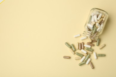 Vitamin pills and bottle on beige background, top view. Space for text