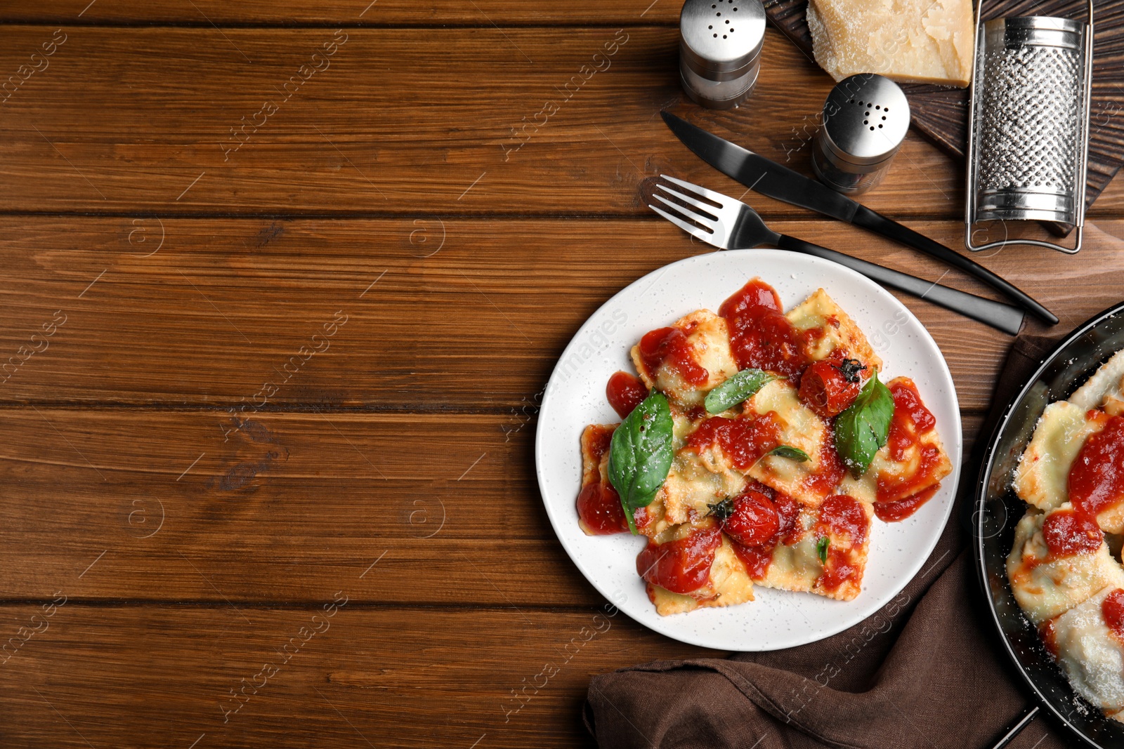 Photo of Tasty ravioli with tomato sauce served on wooden table, flat lay. Space for text