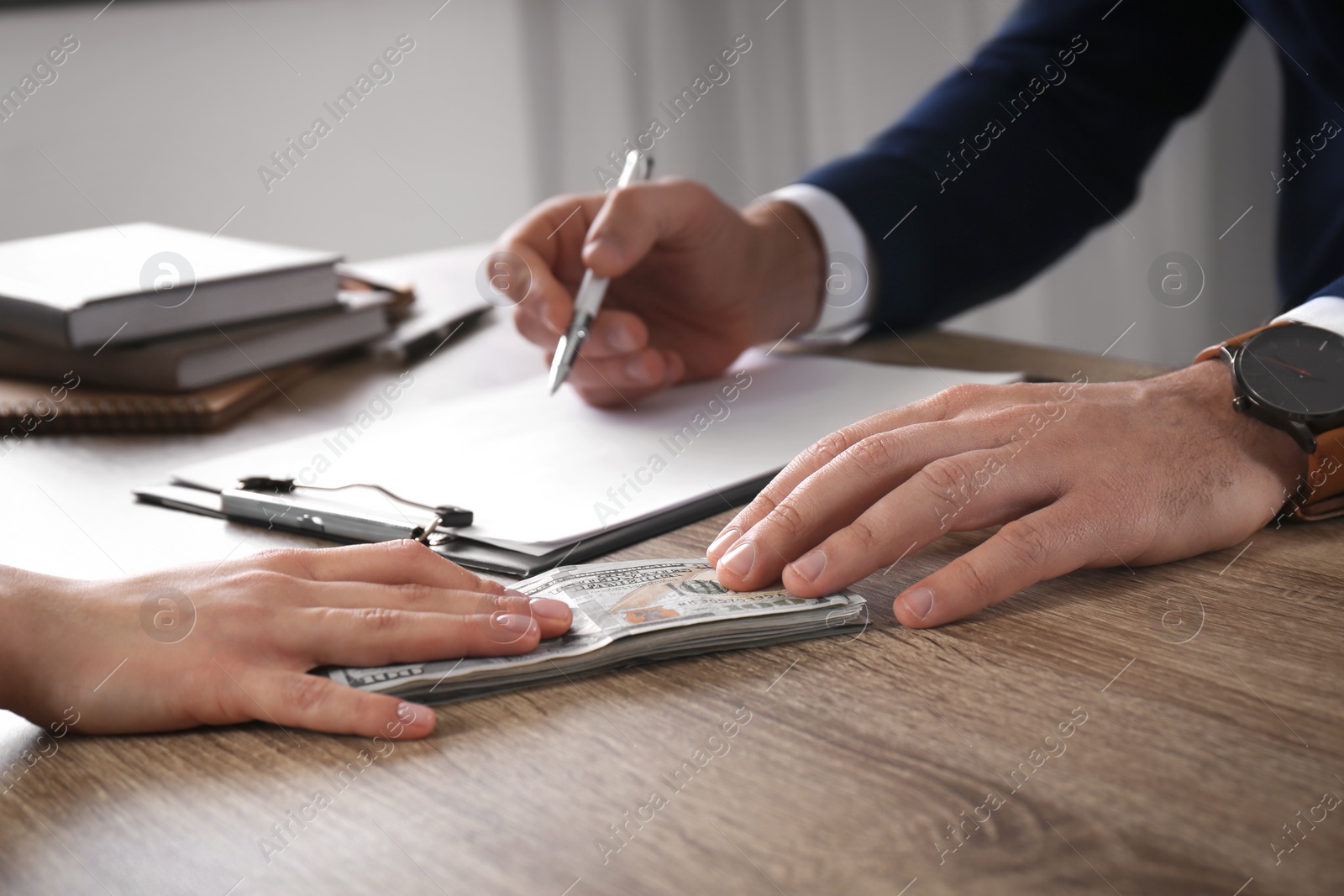 Photo of Woman giving bribe to man at table in office, closeup