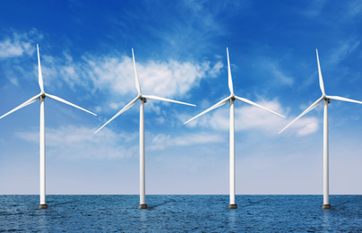 Floating wind turbines installed in sea under blue sky. Alternative energy source 