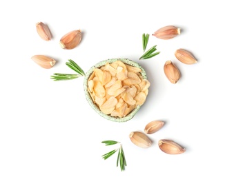 Cloves, rosemary and bowl with dried garlic flakes on white background